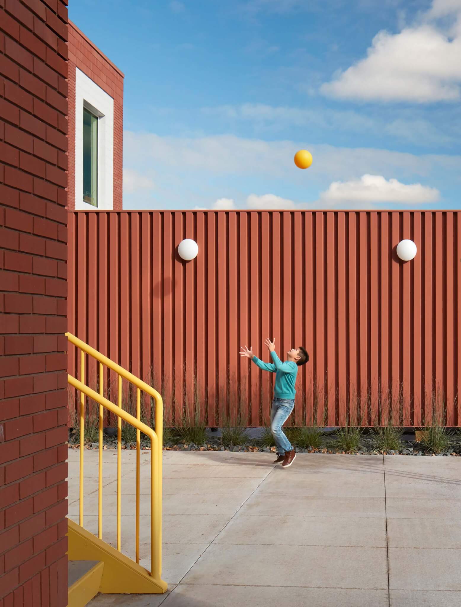 kid juggling in front of wall