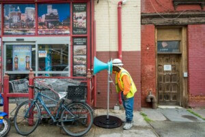 person listening through speaker device on street in Gowanus