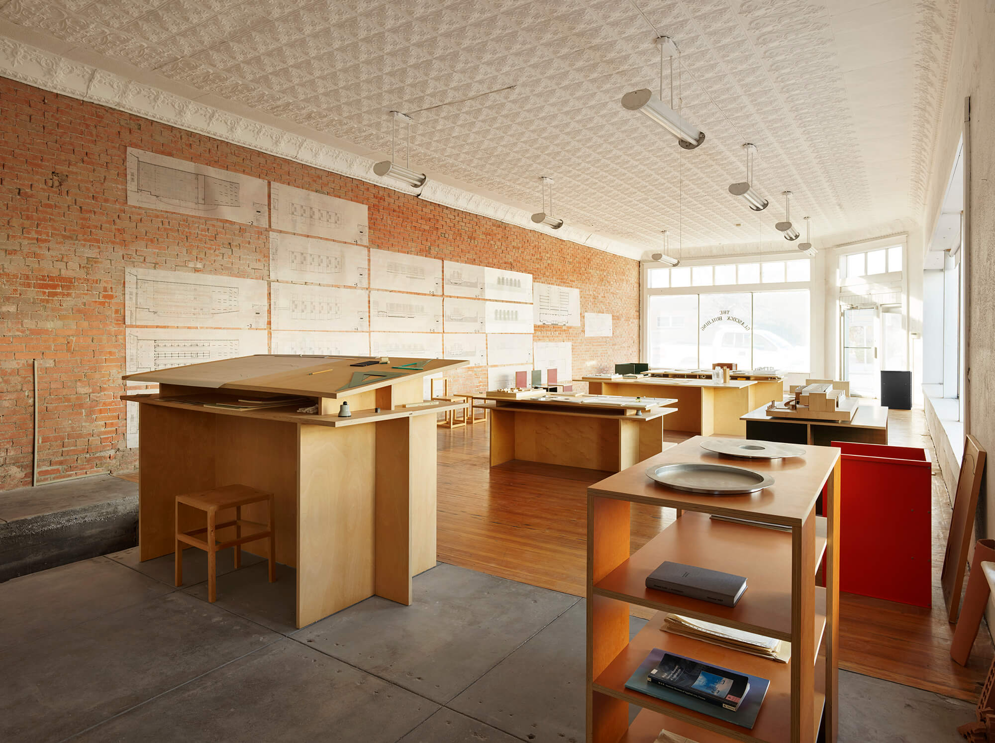 interior view showing drawings on walls and tables with objects on view